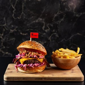 Barbecue burger s dvoubarevným coleslawem, smaženou cibulkou, čedarem, “slaninou”
z lilku, bbq omáčka a rajčaty
